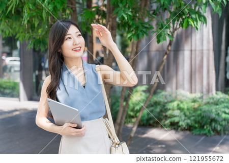 Businesswoman holding a tablet device in an office district 121955672