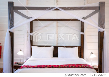 Four poster bed with white mosquito net. 121955696
