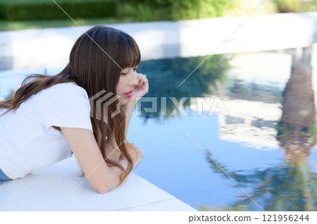 Woman standing by the pool Woman standing by the pool 121956244
