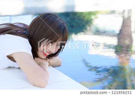 Woman standing by the pool 121956251