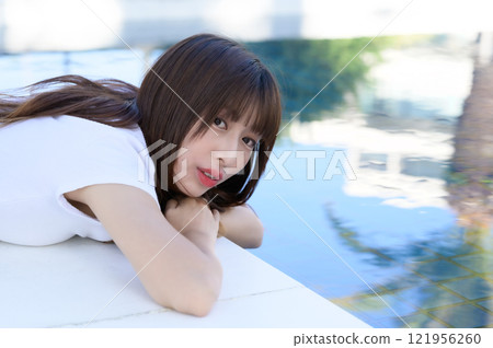 Woman standing by the pool 121956260