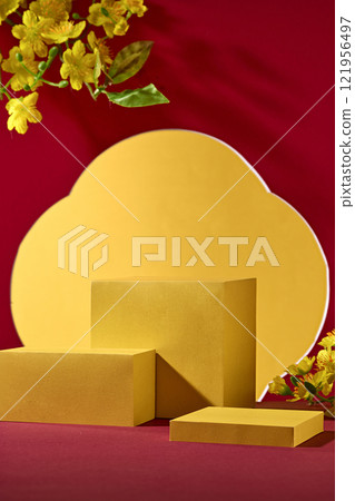 A product ad concept for the Chinese New Year. A side view of some empty yellow presentation product podiums with some yellow apricot blossoms set against a red and golden backdrop. A product ad concept for the Chinese New Year. A side view of some empty yellow presentation product podiums with some yellow apricot blossoms set against a red and golden backdrop. 121956497