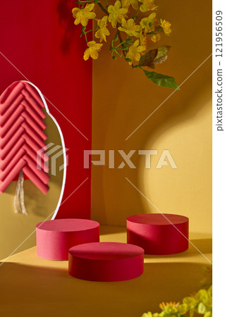 A overhead view of  some red cylindrical pedestal for product display, a pale yellow background, and a dark red wall decorated with a firework and yellow apricot blooms, ideal for the Chinese New Year 121956509