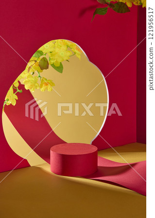 Lunar New Year theme product display image, overhead view of a red cylindrical platform. A flower-shaped cutout in a red wall reveals a gold backdrop, yellow apricot blossoms, and a flowing red paper. 121956517