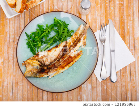 Grilled sea bass fish served with arugula Grilled sea bass fish served with arugula 121956965