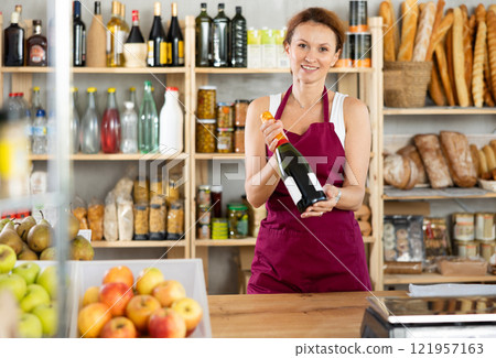 Portrait of female seller offering to buy champagne for festive table Portrait of female seller offering to buy champagne for festive table 121957163