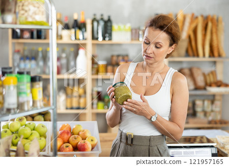 Adult woman choosing green peas in grocery store Adult woman choosing green peas in grocery store 121957165