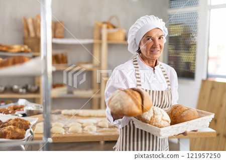 Portrait of positive mature woman bakery worker Portrait of positive mature woman bakery worker 121957250
