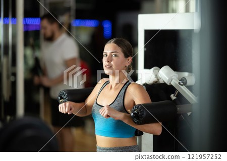 Woman training her hands in the machine 121957252