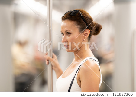 Portrait of woman traveling by modern city subway carriage Portrait of woman traveling by modern city subway carriage 121957309