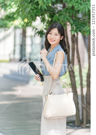 辦公區樹蔭下拿著平板電腦的女商人 121957351