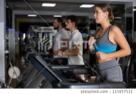 Focused girl works out with treadmill during class at fitness club 121957531