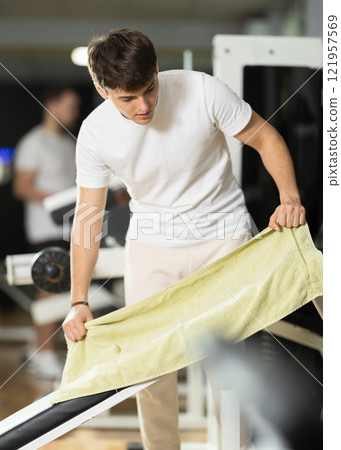 Guy lays a towel in the gym 121957569