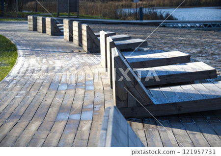Wooden Loungers on Frosty Beach Boardwalk in Winter Morning 121957731