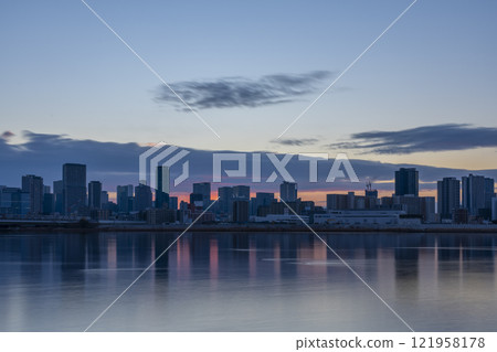 The skyscrapers and sunrise in Umeda, Osaka, seen across the Yodo River 121958178