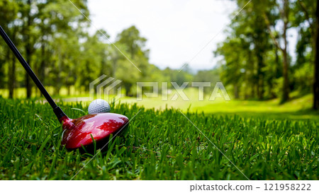 Golf club and ball in green grass. Golf balls on course with clubs ready for golf in the first short. 121958222