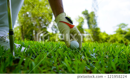 golfer playing golf in the evening golf course, on sun set evening time. golfer playing golf in the evening golf course, on sun set evening time. 121958224