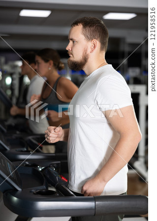 Man works out on the treadmill 121958516