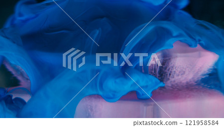 Mystical smoke. Hypnotic fluid. Pink violet blue smooth curl paint floating on glass blue crystal diamond in water defocused abstract background. 121958584