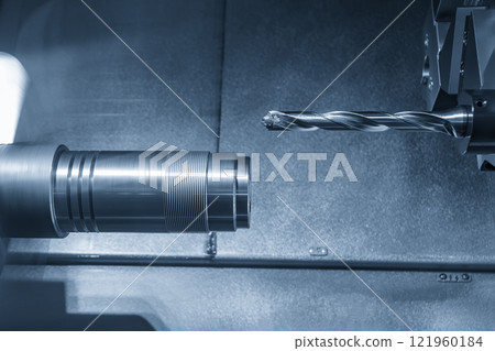 The CNC lathe machine drilling process the metal parts in the light blue scene. The CNC lathe machine drilling process the metal parts in the light blue scene. 121960184