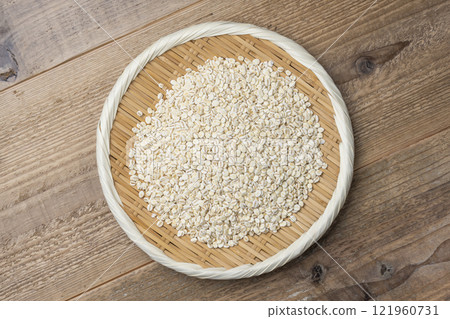 Aerial view of rolled barley in a bamboo basket on a wooden background 121960731