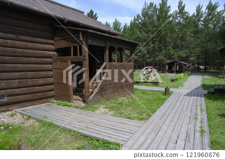 The porch of a restored 19th century wooden house with a lawn and wooden paths in Ulan-Ude, Russia 121960876