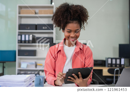 Businesswomen hand working with tablet and laptop computer with documents on office desk in modern office. Businesswomen hand working with tablet and laptop computer with documents on office desk in modern office. 121961453