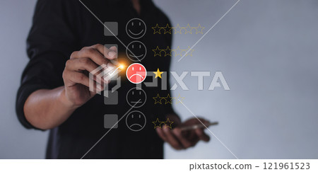 Young man with smartphone mobile hand hold a pen touching to review and gives 1 star Young man with smartphone mobile hand hold a pen touching to review and gives 1 star 121961523