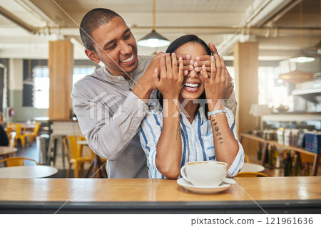 A man covering a happy womans eyes for as a greeting, for a surprise and on a restaurant, cafe or fast food store date. An in love, dating or married young couple smile while on hot coffee lunch 121961636
