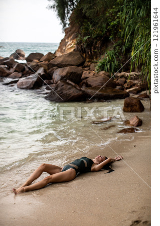 Enjoying a Relaxing Beach Moment A Serene Pose on the Warm Sandy Shore with Beauty 121961644