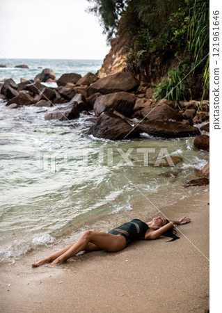 Enjoying a Relaxing Beach Moment A Serene Pose on the Warm Sandy Shore with Beauty 121961646