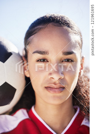 Serious, female and young soccer athlete with a football ready for a workout, match or exercise. Portrait of a teen student girl face in a sport uniform before fitness and school sports training Serious, female and young soccer athlete with a football ready for a workout, match or exercise. Portrait of a teen student girl face in a sport uniform before fitness and school sports training 121961695