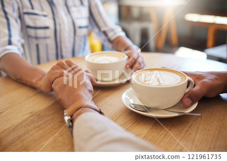 Coffee, break and dating couple holding hands on a romantic date at a cafe, restaurant or coffee shop. Man, woman or people touching, in love and romance on anniversary or valentines day together 121961735