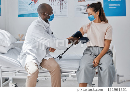 Doctor, medical and healthcare taking patient blood pressure at the hospital during covid pandemic. Health, consulting and worker helping woman with arm monitor for heart and healthy checkup. 121961861