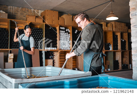 Winemaker workers in the process of making wine with a wine press tool or equipment in a warehouse, winery or distillery. Woman, man or vintner people pressing juice of grapes for alcohol industry Winemaker workers in the process of making wine with a wine press tool or equipment in a warehouse, winery or distillery. Woman, man or vintner people pressing juice of grapes for alcohol industry 121962148