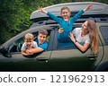 A joyful and cheerful family of four enjoying a funfilled outdoor trip together in their spacious SUV 121962913