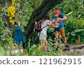 A family joyfully navigates through a lush green forest, sharing wonderful moments together in nature 121962915