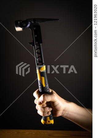 Hand holding hammer, which is perfect for an array of DIY tasks and home improvement projects 121963020