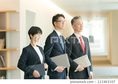 Business people lining up in an office corridor 121963107