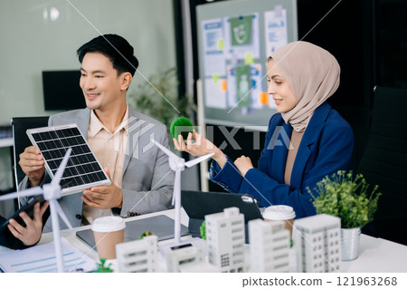 Group of diverse multiethnic businesspeople standing neare table looking at model of building from residential project. 121963268