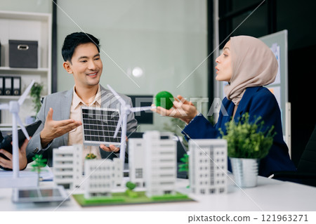 Group of diverse multiethnic businesspeople standing neare table looking at model of building from residential project. Green business company and Solar Energy Environment city 121963271