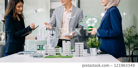 Group of diverse multiethnic businesspeople standing neare table looking at model of building from residential project. Green business company and Solar Energy Environment city 121963349