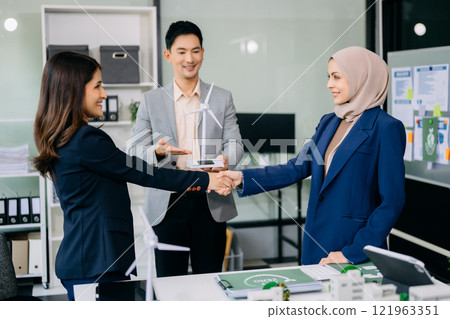 Group of diverse multiethnic businesspeople standing neare table looking at model of building from residential project. Green business company and Solar Energy Environment city 121963351