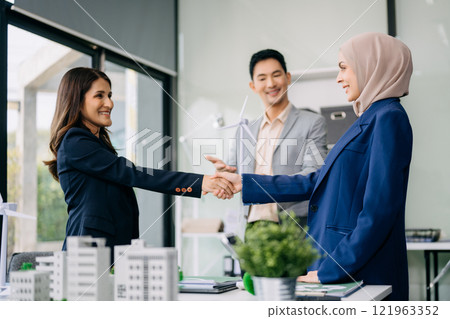 Group of diverse multiethnic businesspeople standing neare table looking at model of building from residential project. Green business company and Solar Energy Environment city 121963352