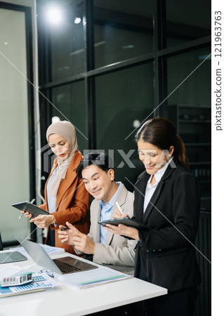 Asian businesspeople while collaborating on a new project.  using a laptop and tablet 121963763
