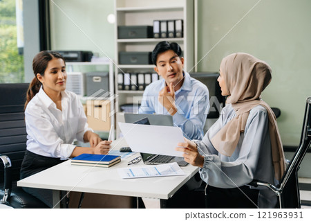 Happy businesspeople while collaborating on a new project in an office. 121963931