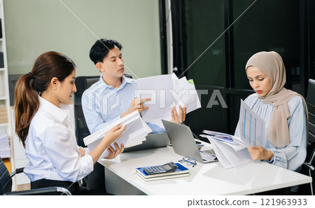 Asian businesspeople while collaborating on a new project.  using a laptop and tablet 121963933