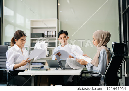 Asian businesspeople while collaborating on a new project.  using a laptop and tablet 121963934