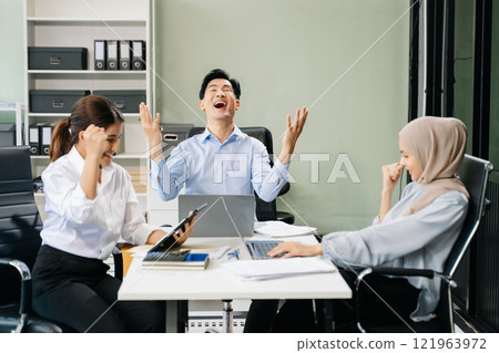 Happy businesspeople while collaborating on a new project in an office. 121963972