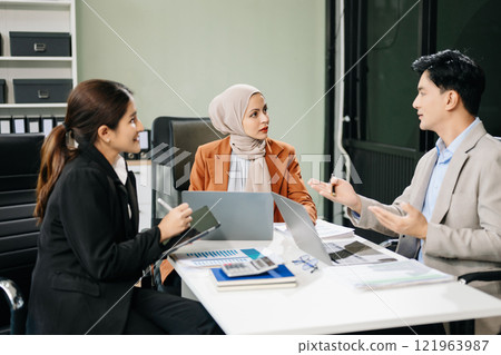 Asian businesspeople while collaborating on a new project.  using a laptop and tablet 121963987